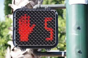 Crosswalk signal showing red hand with five seconds left