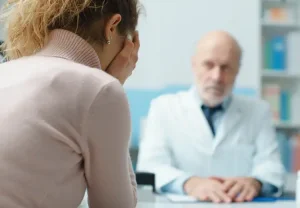 Doctor telling woman bad news in hospital and she is upset